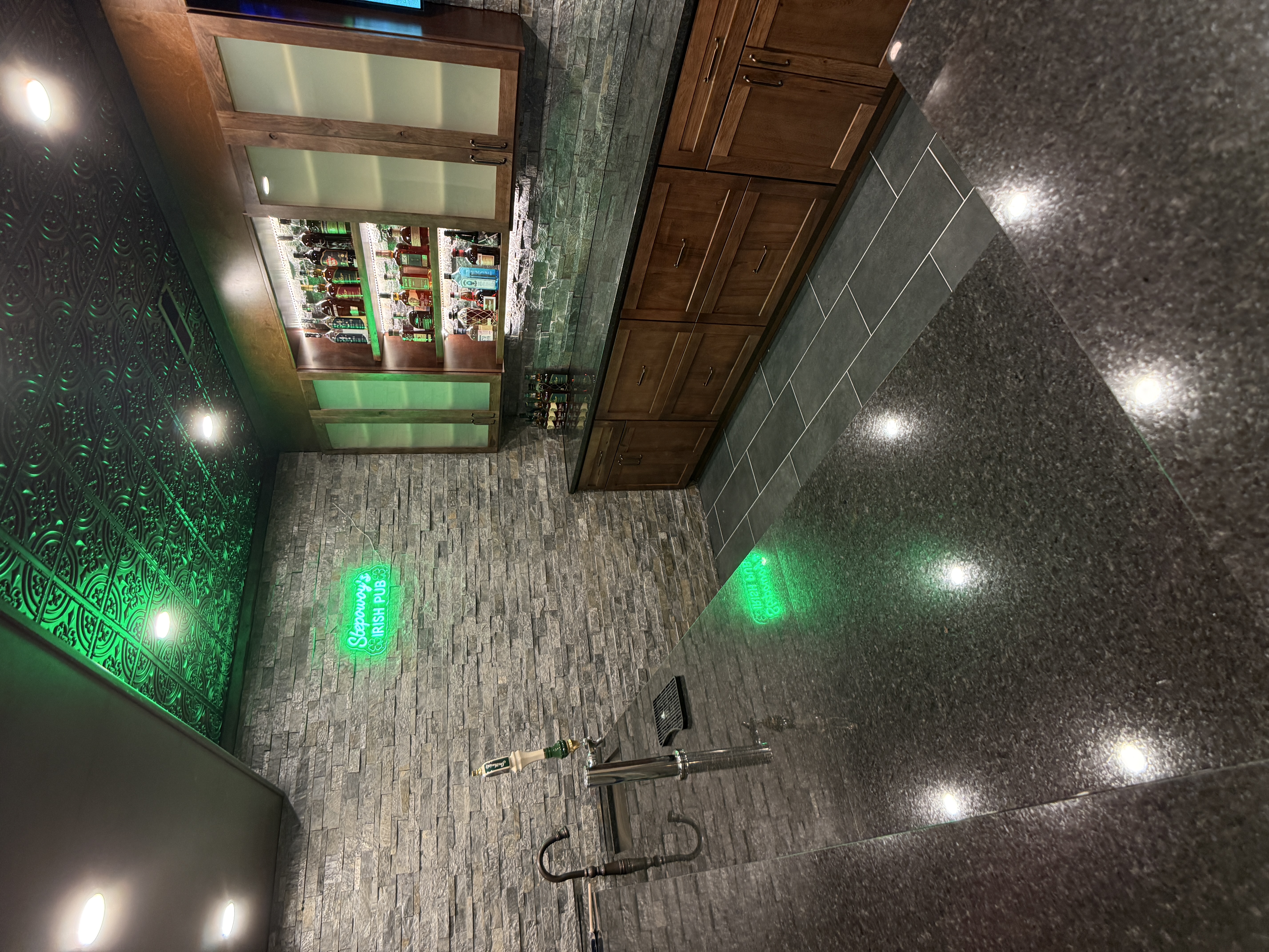 Basement wet bar with kegerator tap and stacked stone backsplash by Serge Construction